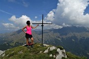 56 Alla croce di vetta della Corna Grande (2089 m) con vista a dx sul Tre Signori avvolto nelle nuvole 